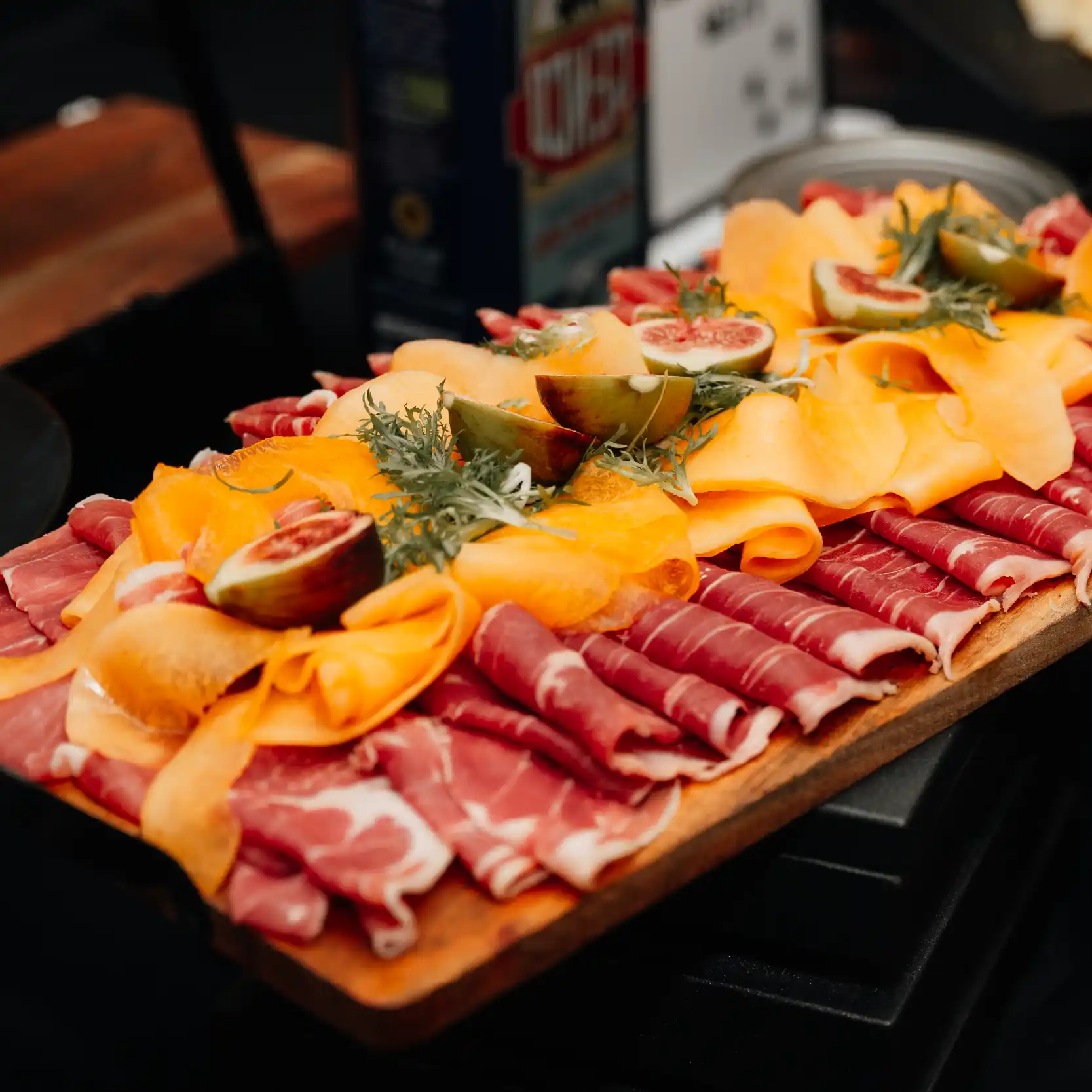 cold Italian meat slices, well presented on a wood board.