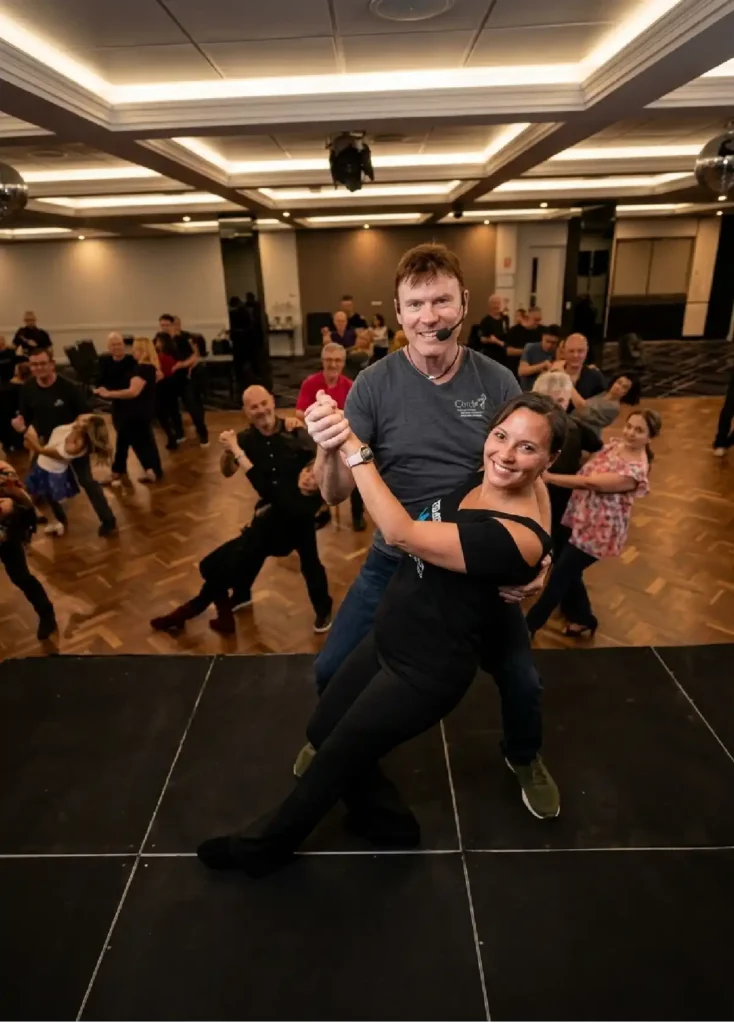 ceroc dancing couple posing smiling in a modern venue