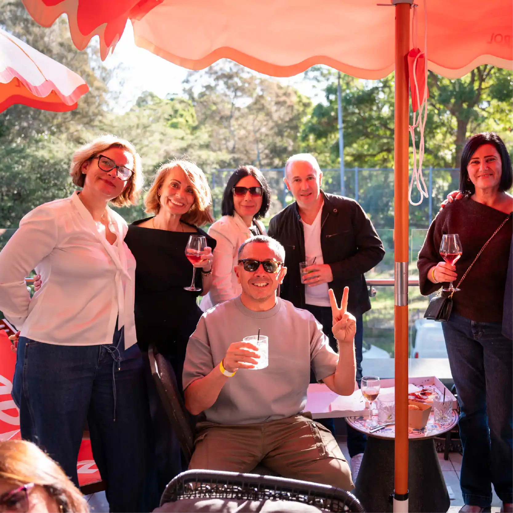 Group of people enjoying food and smiling to the camera