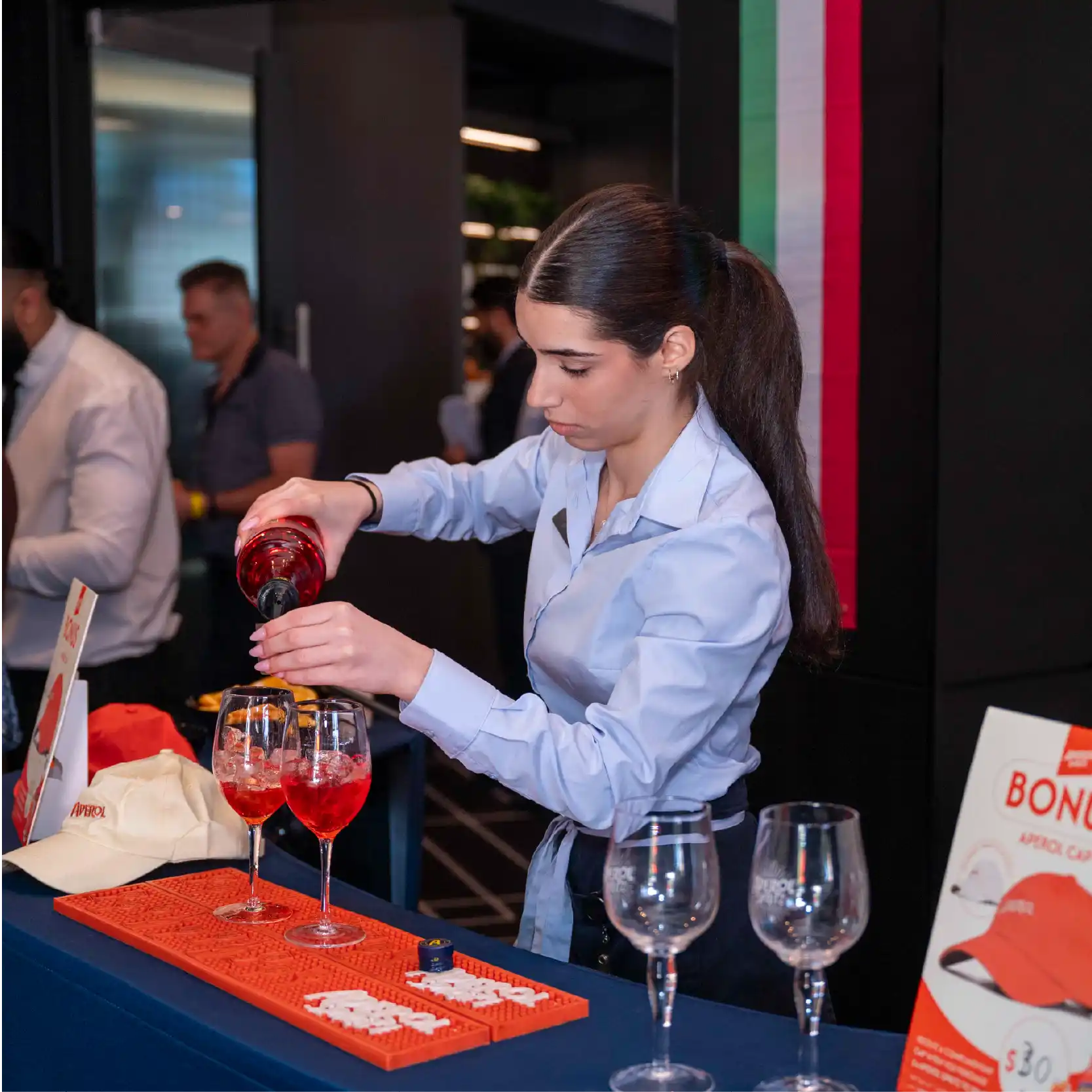 A bartender mixing Aperol drinks